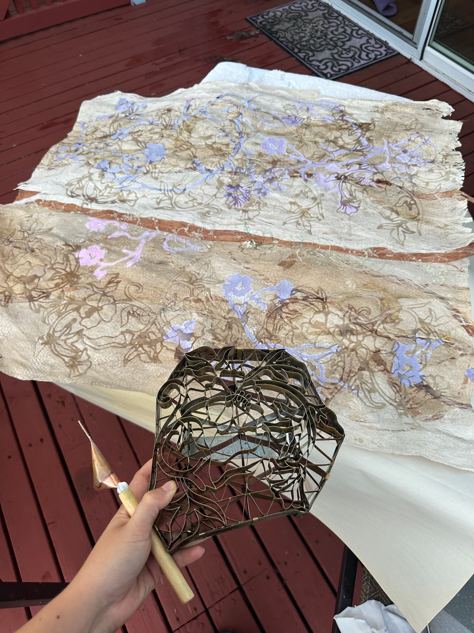 Batik tools: cap-block, and canting-pen in use on kapa piece.